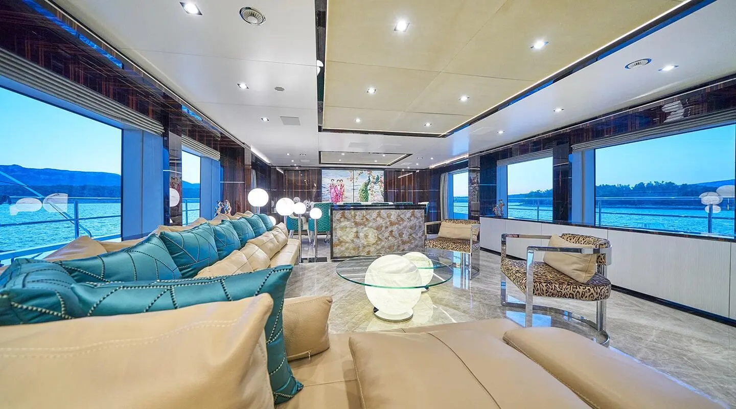 Luxurious yacht cabin lounge at sunset with blue accents and beige seating