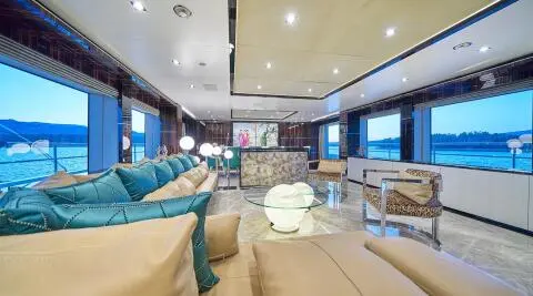 Luxurious yacht cabin lounge at sunset with blue accents and beige seating