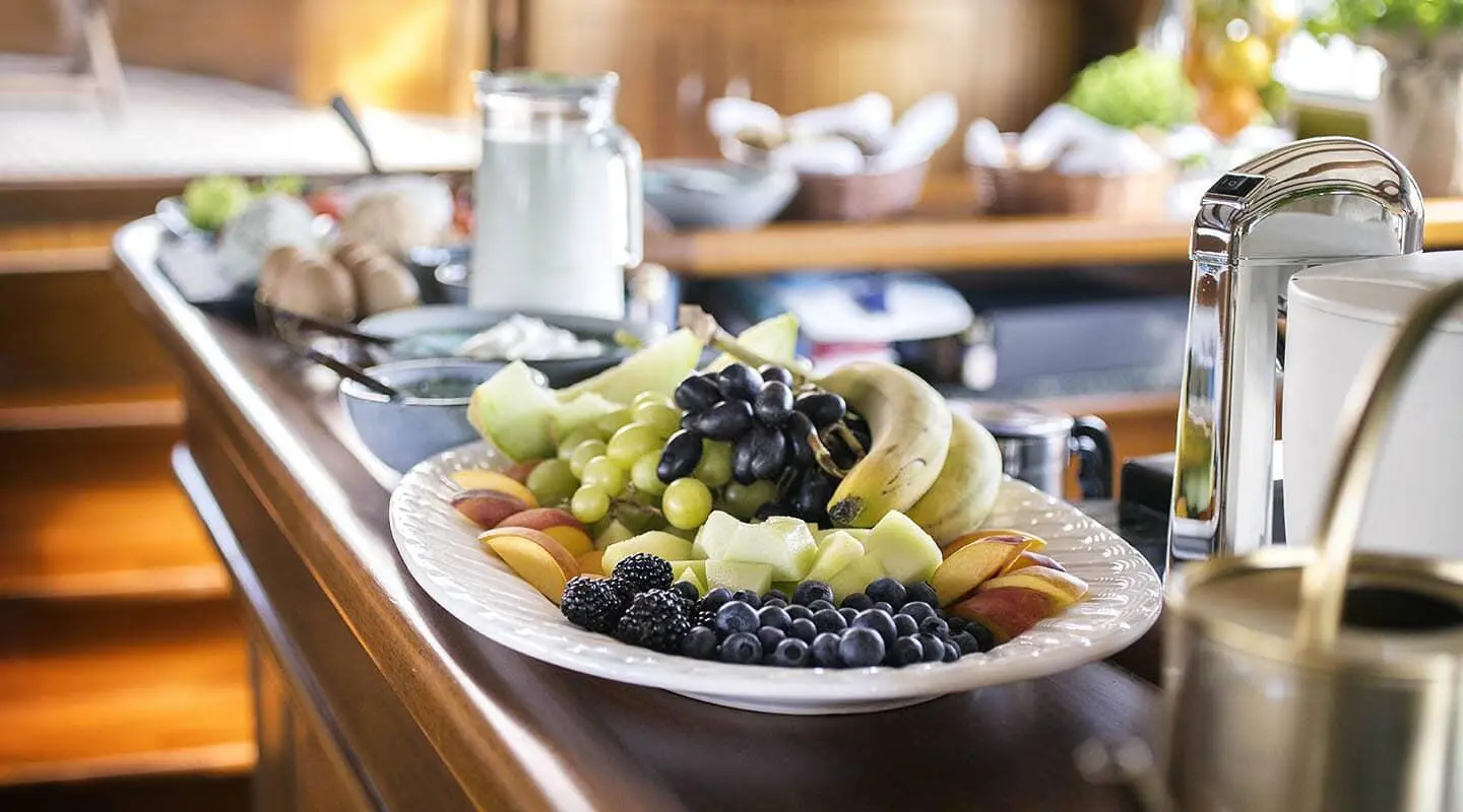 A luxurious dining scene on a yacht with a platter of grapes and fruit
