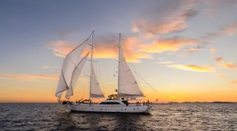Alessandro I sailing at sunset with full white sails on calm sea
