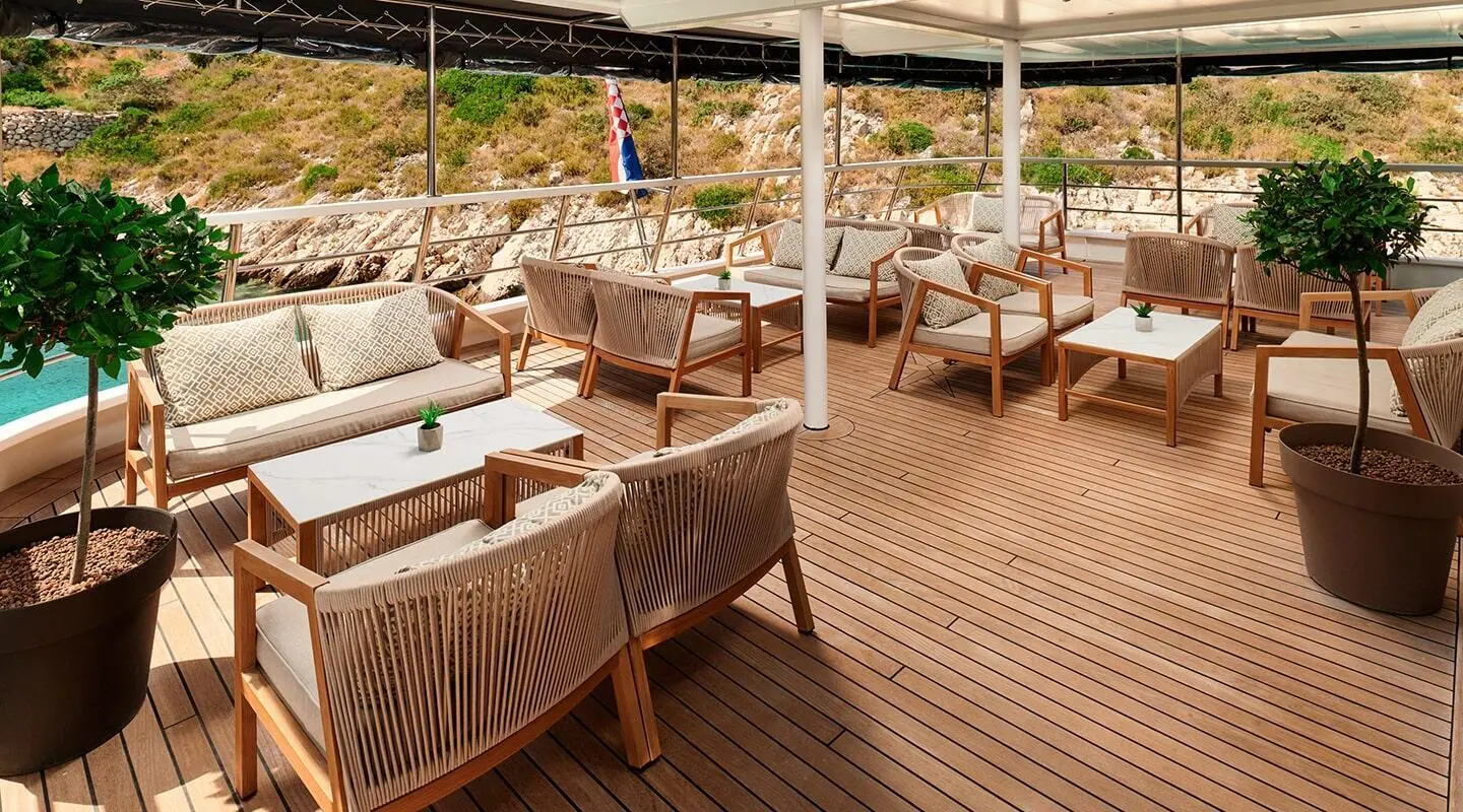 Lupus Mare deck lounge area with wicker chairs and sunshades on wooden planks