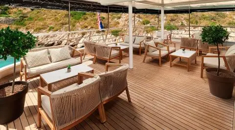 Lupus Mare deck lounge area with wicker chairs and sunshades on wooden planks