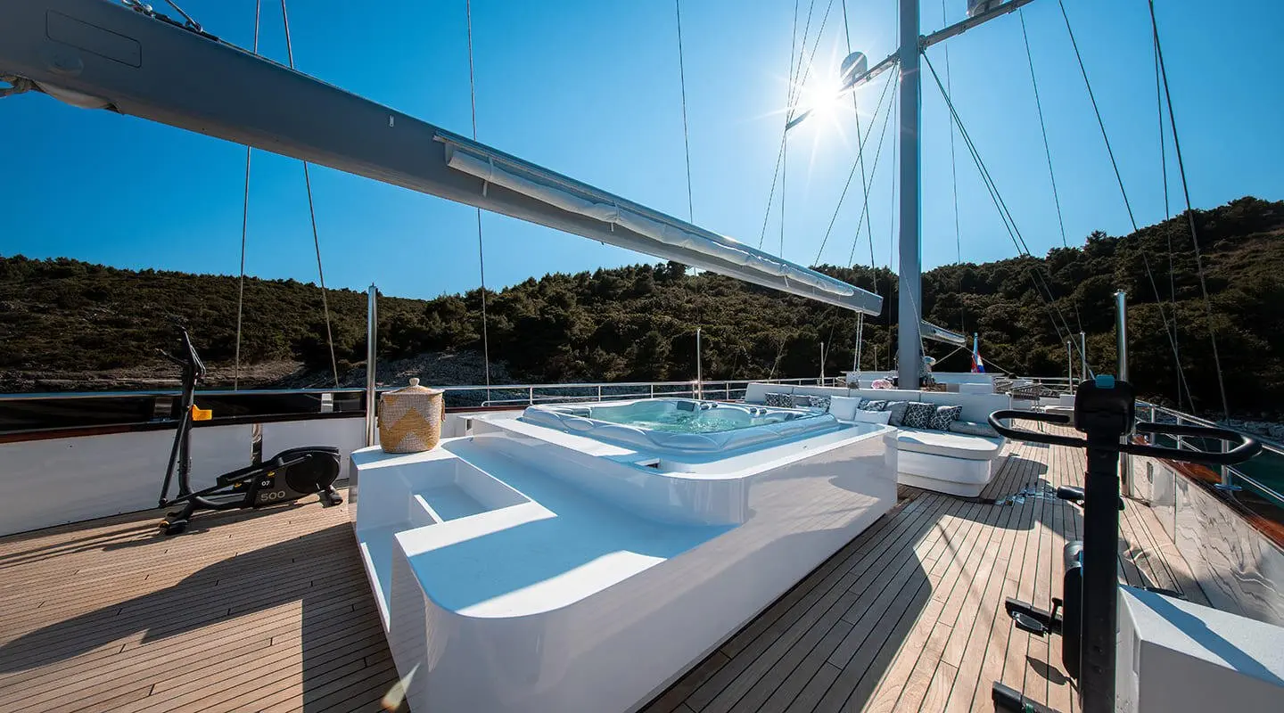 Nocturno yacht deck with white seating and sun-drenched view, sunset horizon
