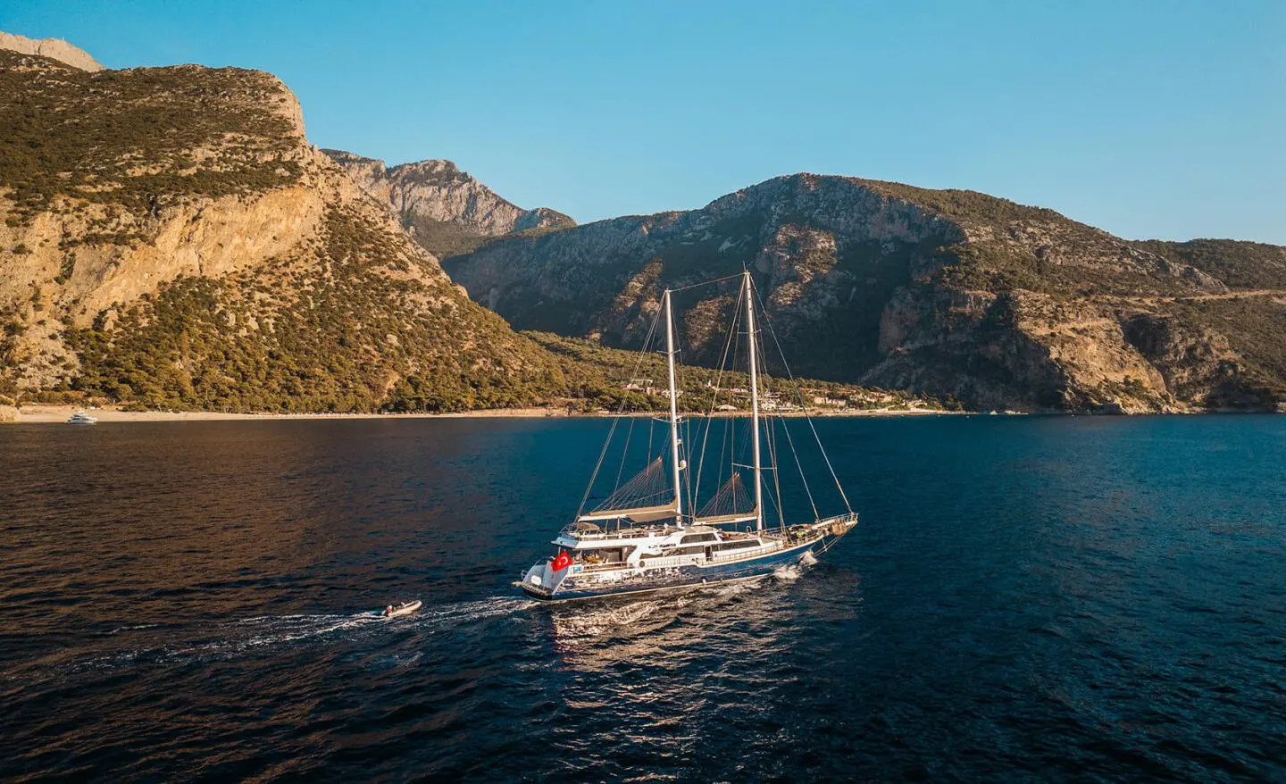 Esma Sultan luxury yacht anchored near rocky cliffs at sunset