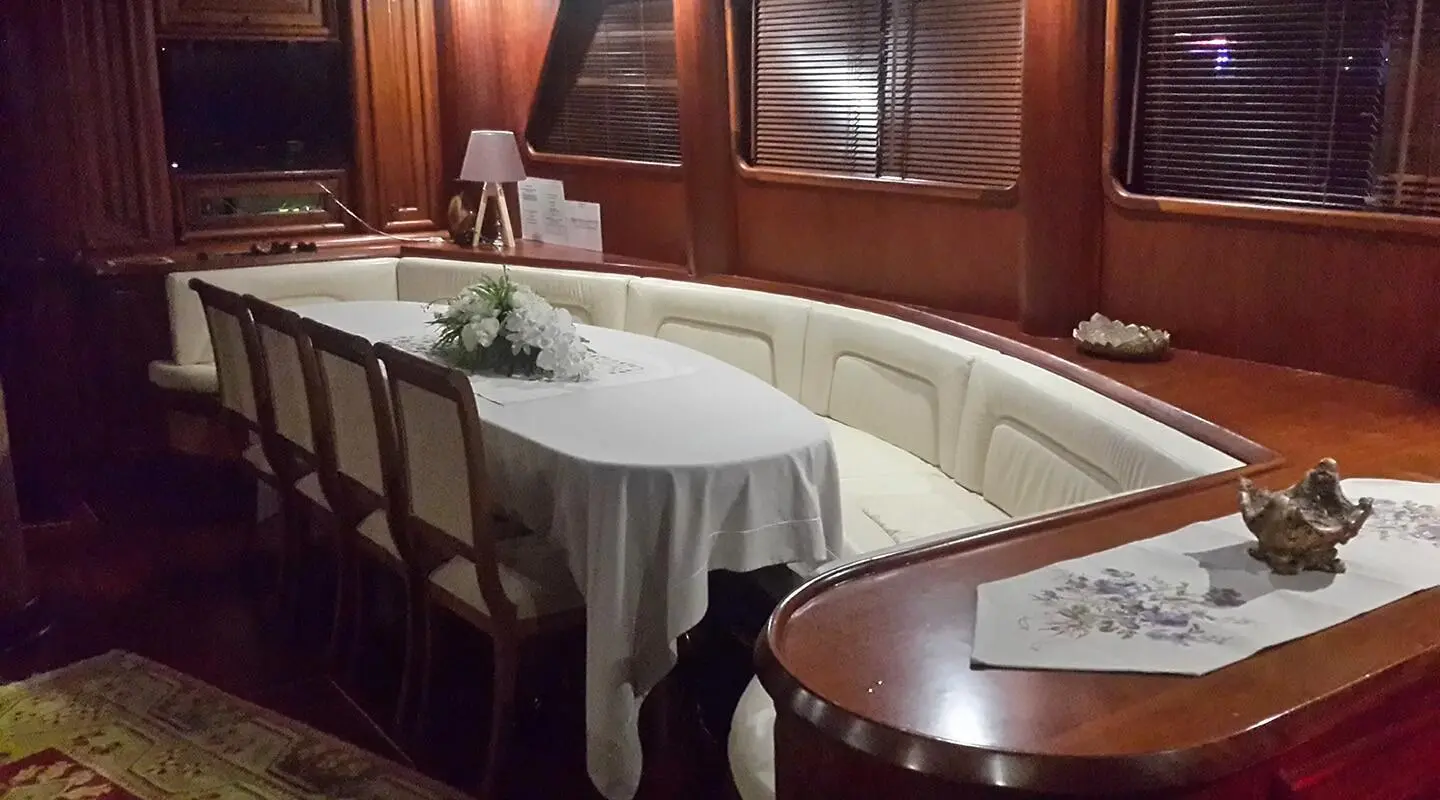 Interior of a luxury yacht dining area with curved seating and round table