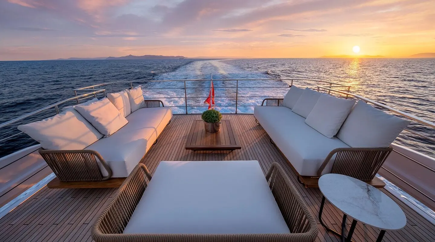 Spica yacht at sunset, outdoor seating on deck with ocean horizon