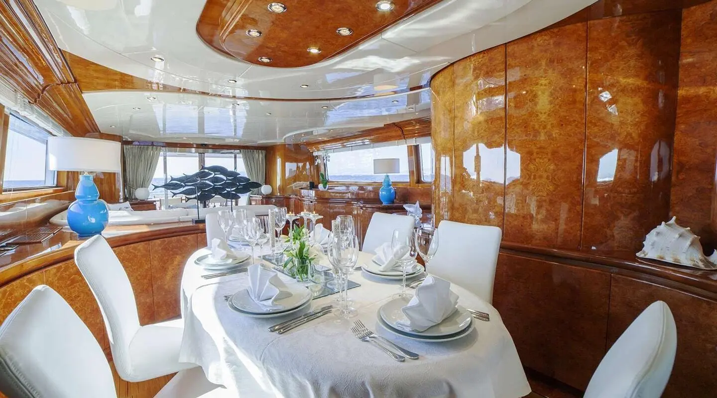 Interior dining area on yacht Zoi with round table set for dinner