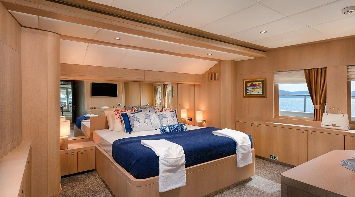 Luxurious cabin aboard Grace yacht with two beds, blue bedding, and wooden paneling