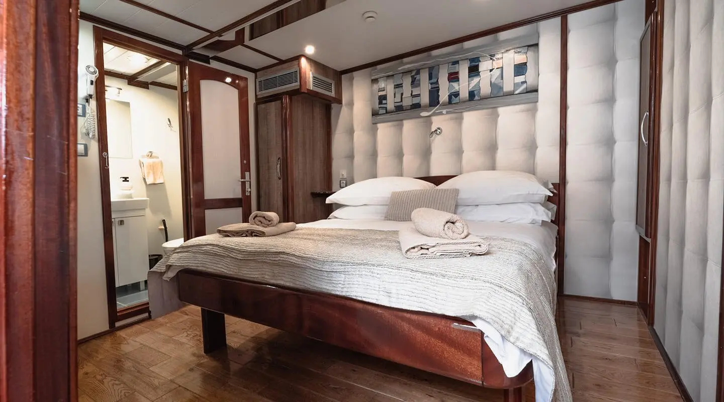 Mendula gulet cabin interior with two-person bed and wooden accents