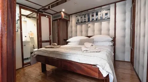 Mendula gulet cabin interior with two-person bed and wooden accents