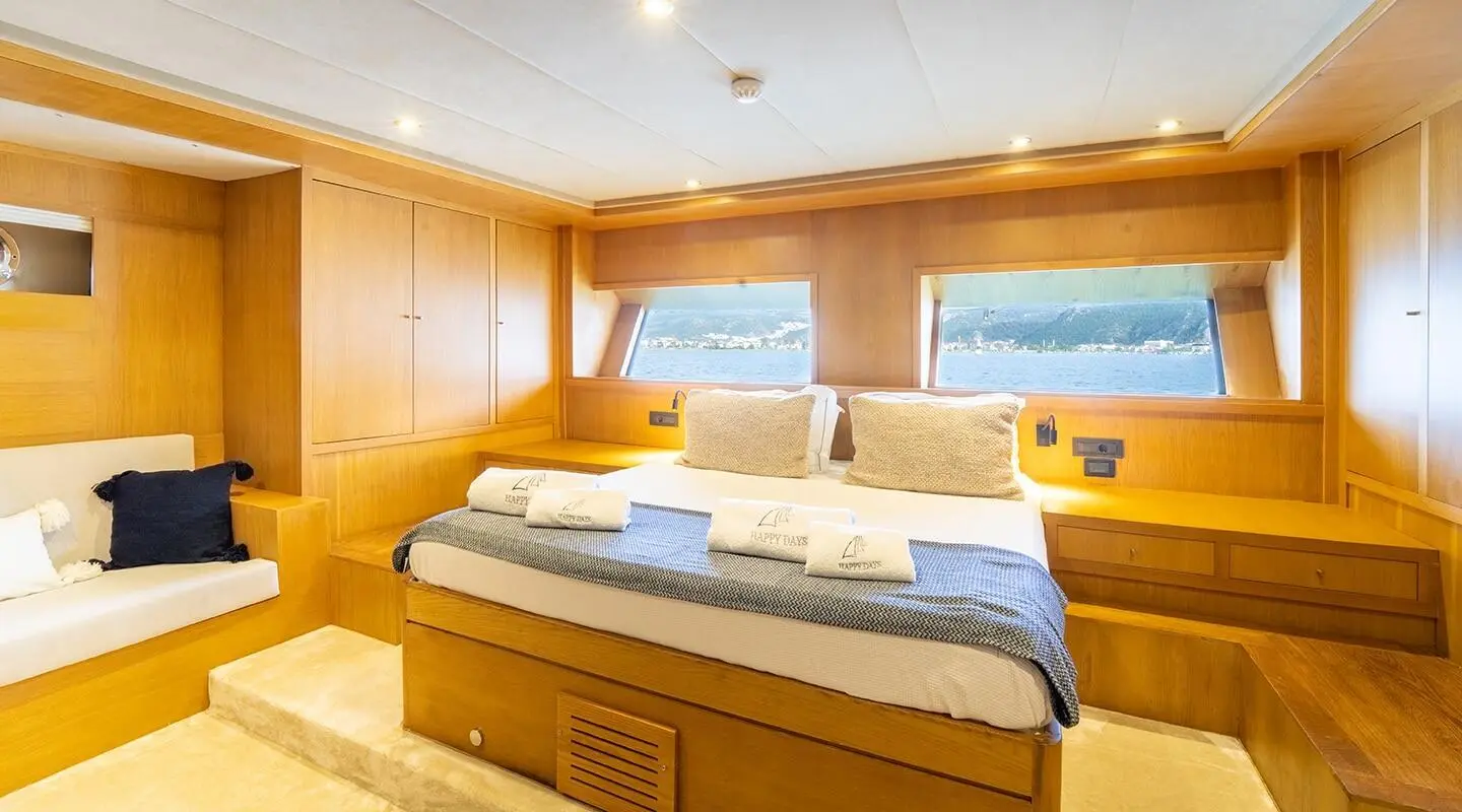 Interior of Happy Days gulet master cabin with two beds and wooden cabinetry