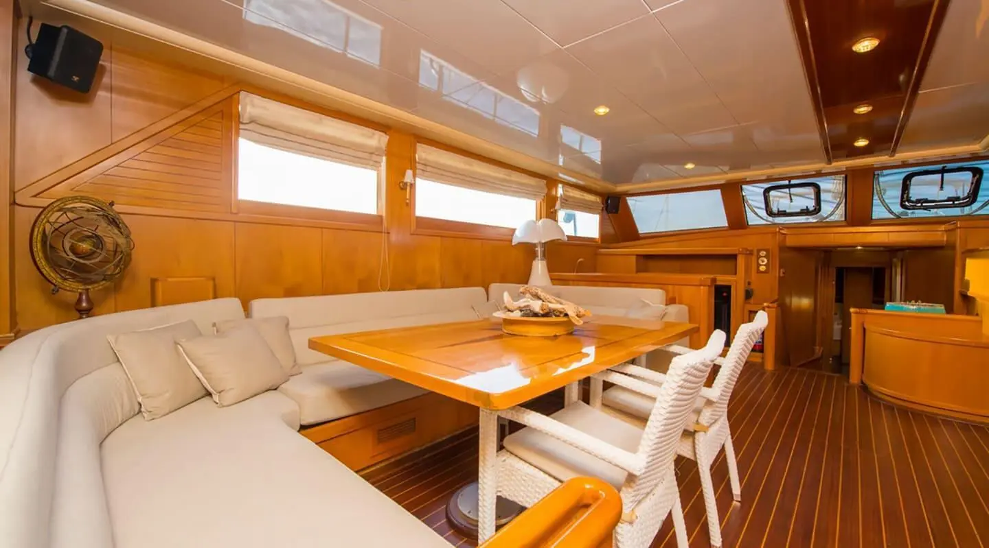 Interior of Mein Schatz yacht with wooden table, seating, and windows