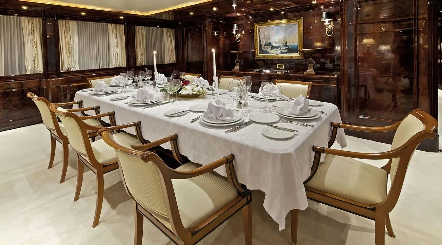 O'Rion yacht dining area aboard sunset-lit deck with table settings