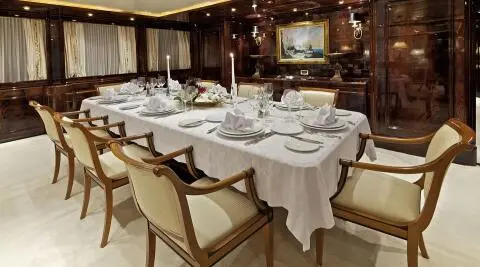 O'Rion yacht dining area aboard sunset-lit deck with table settings