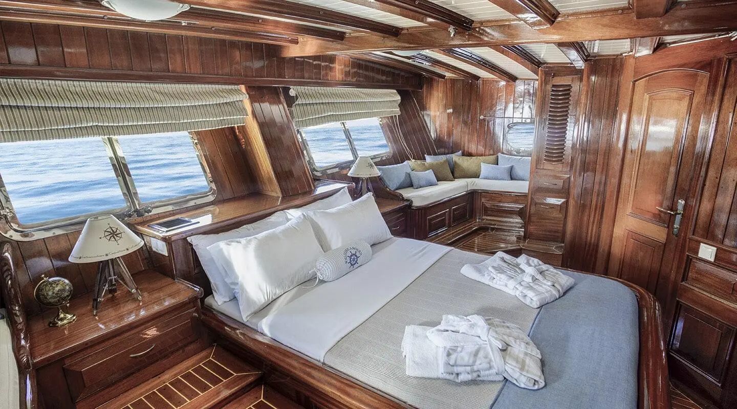Luxurious wooden cabin with a large bed and pillows inside the yacht