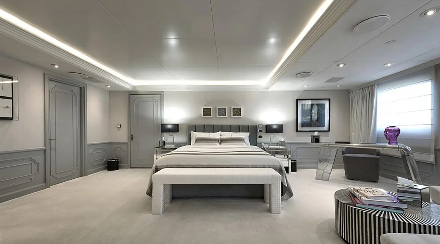 Spacious master bedroom with modern decor and bedside lamps