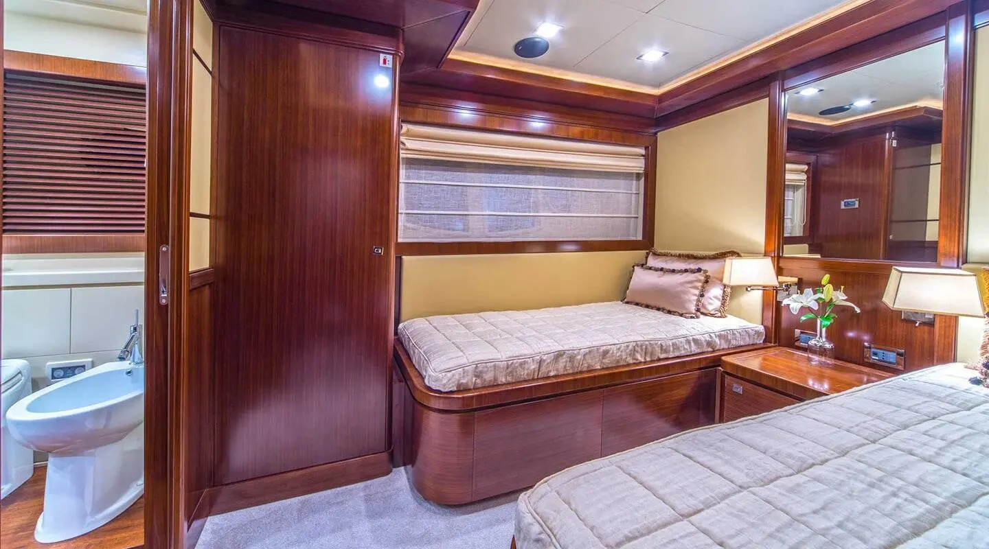 Seventh Sense yacht interior cabin with bed, wood panels, and porthole window