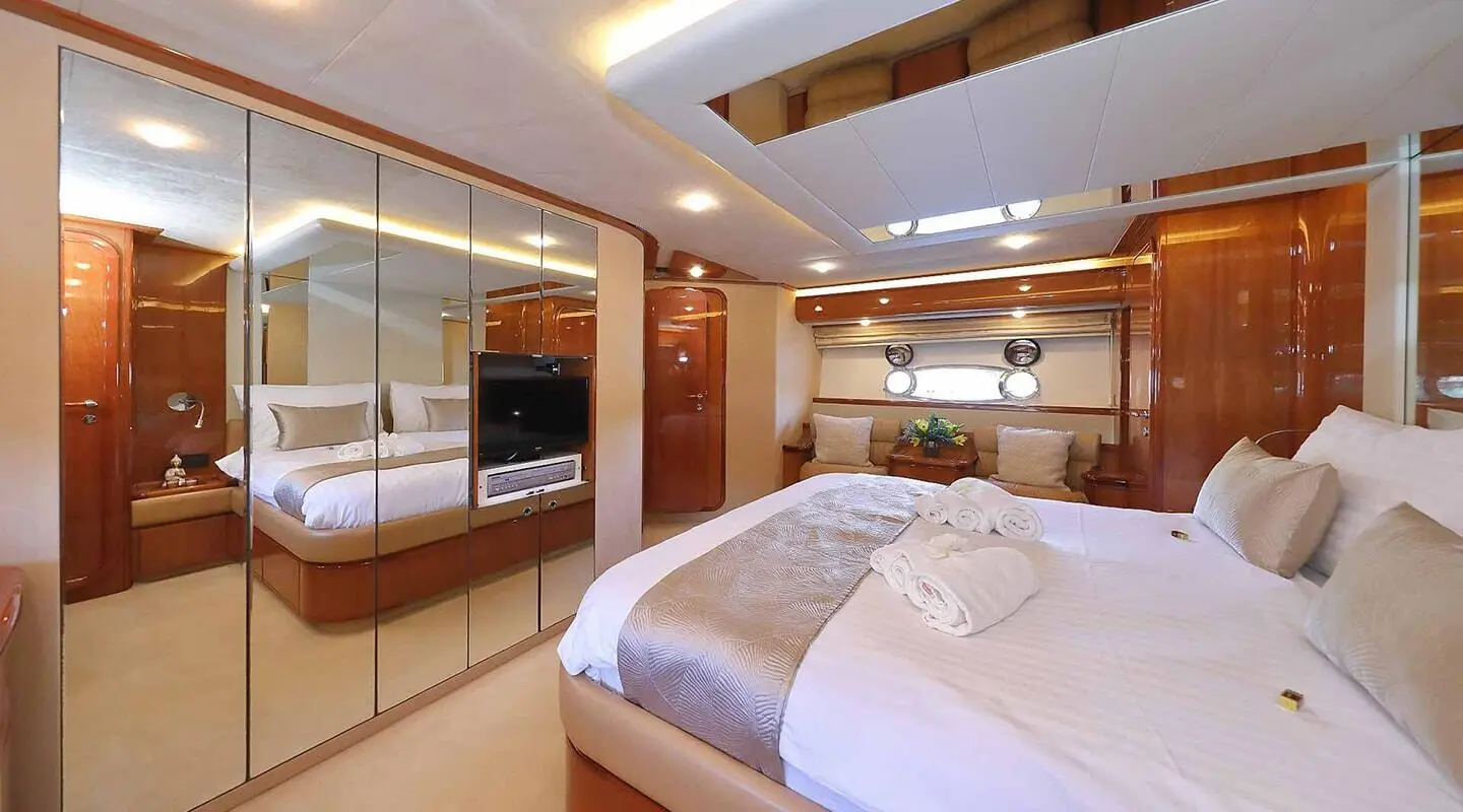 Quo Vadis I master cabin with two beds and wooden cabinetry, warm lighting