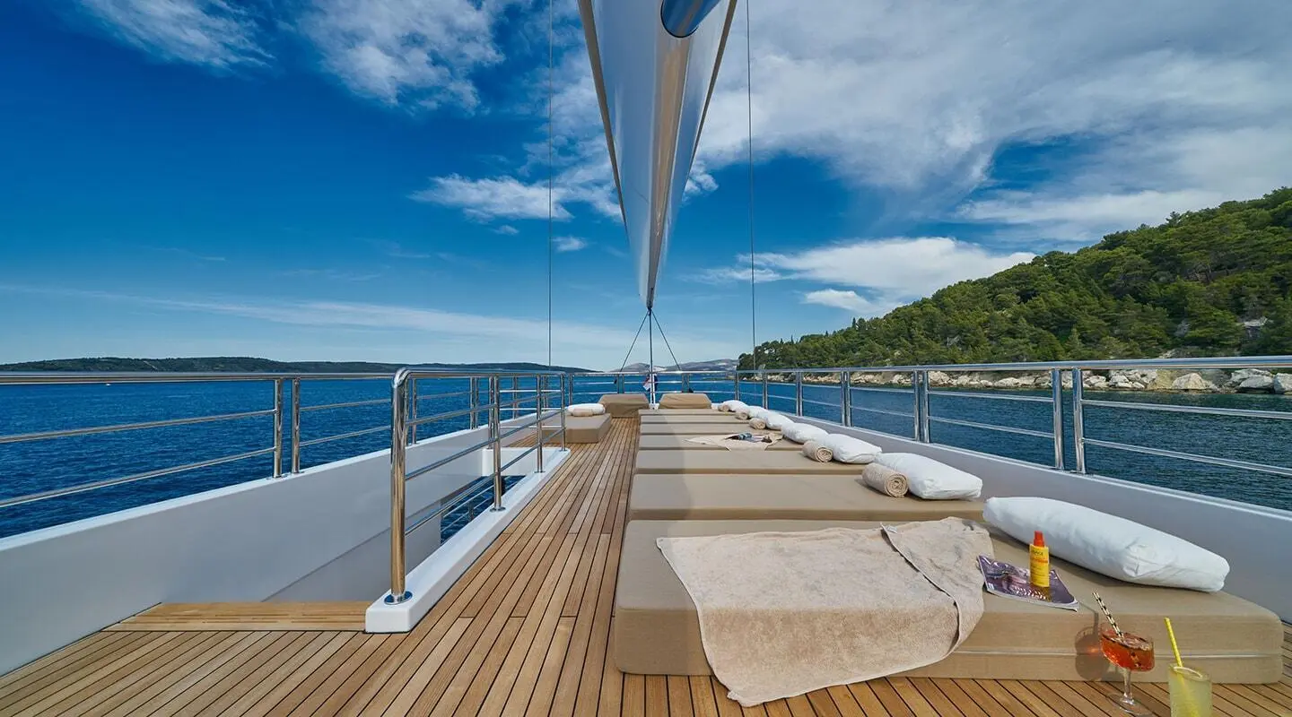 Deck view on Acapella motoryacht, sun loungers, railing, blue sea