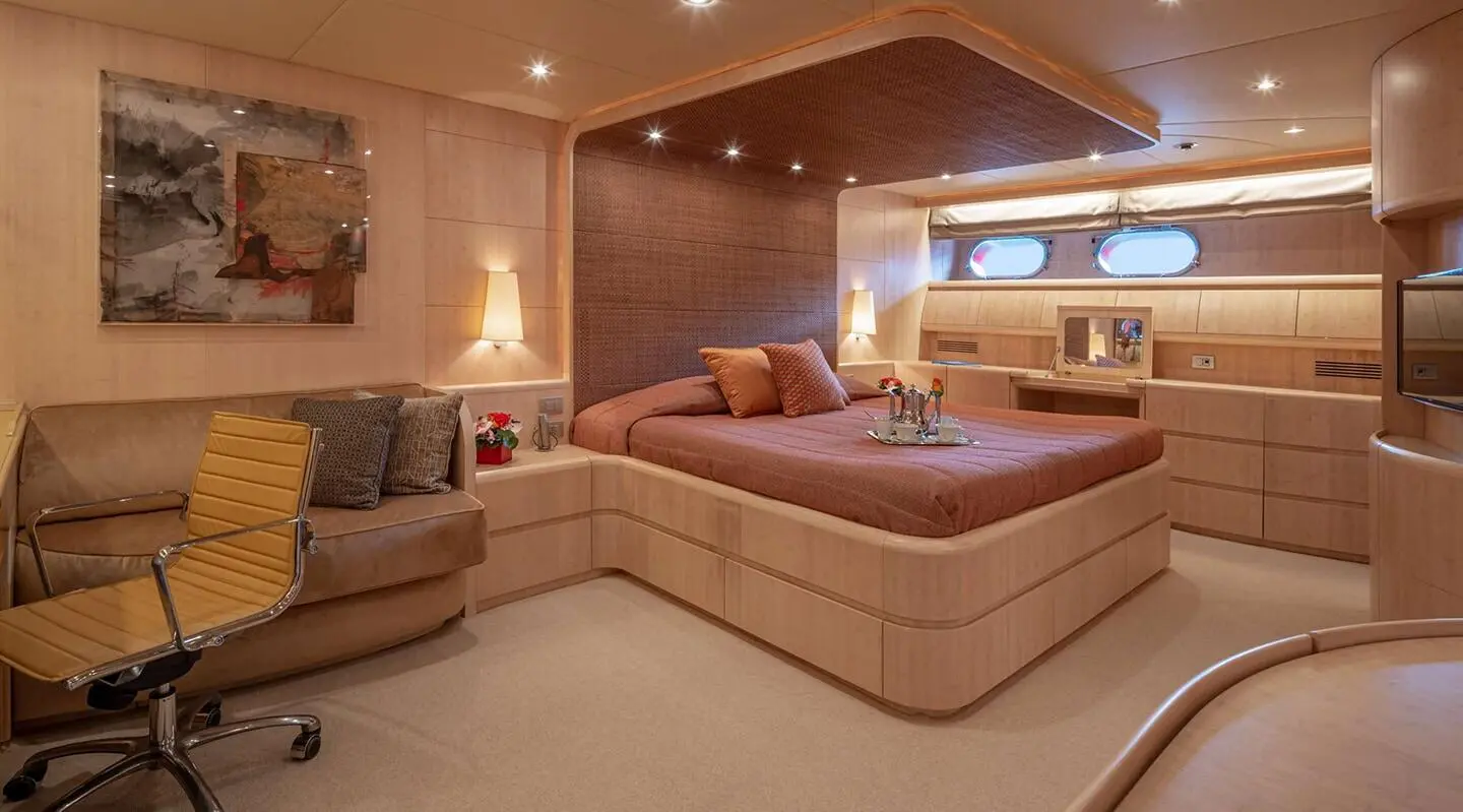 Glaros yacht master cabin with large bed, wooden panels, and soft lighting