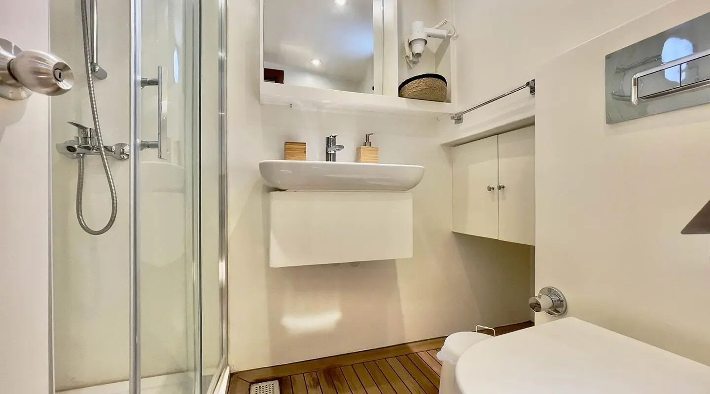 Interior shot of a compact yacht head with shelves, mirror, and cabinet doors
