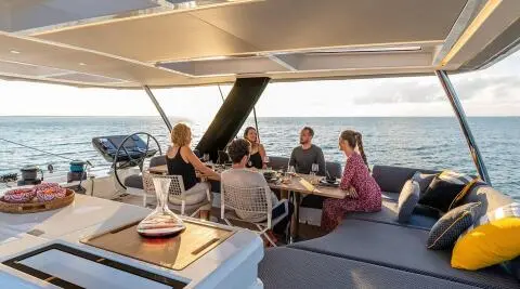 On the Daiquiri yacht, open sea, sunset, five people around a dining table