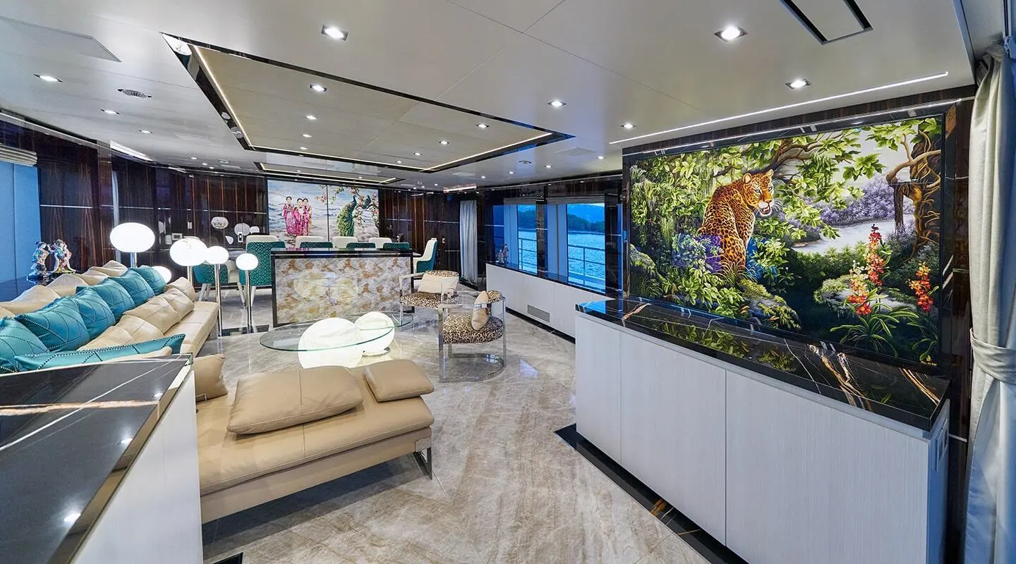 Interior of luxury yacht saloon with beige seating, wood floor, and bar
