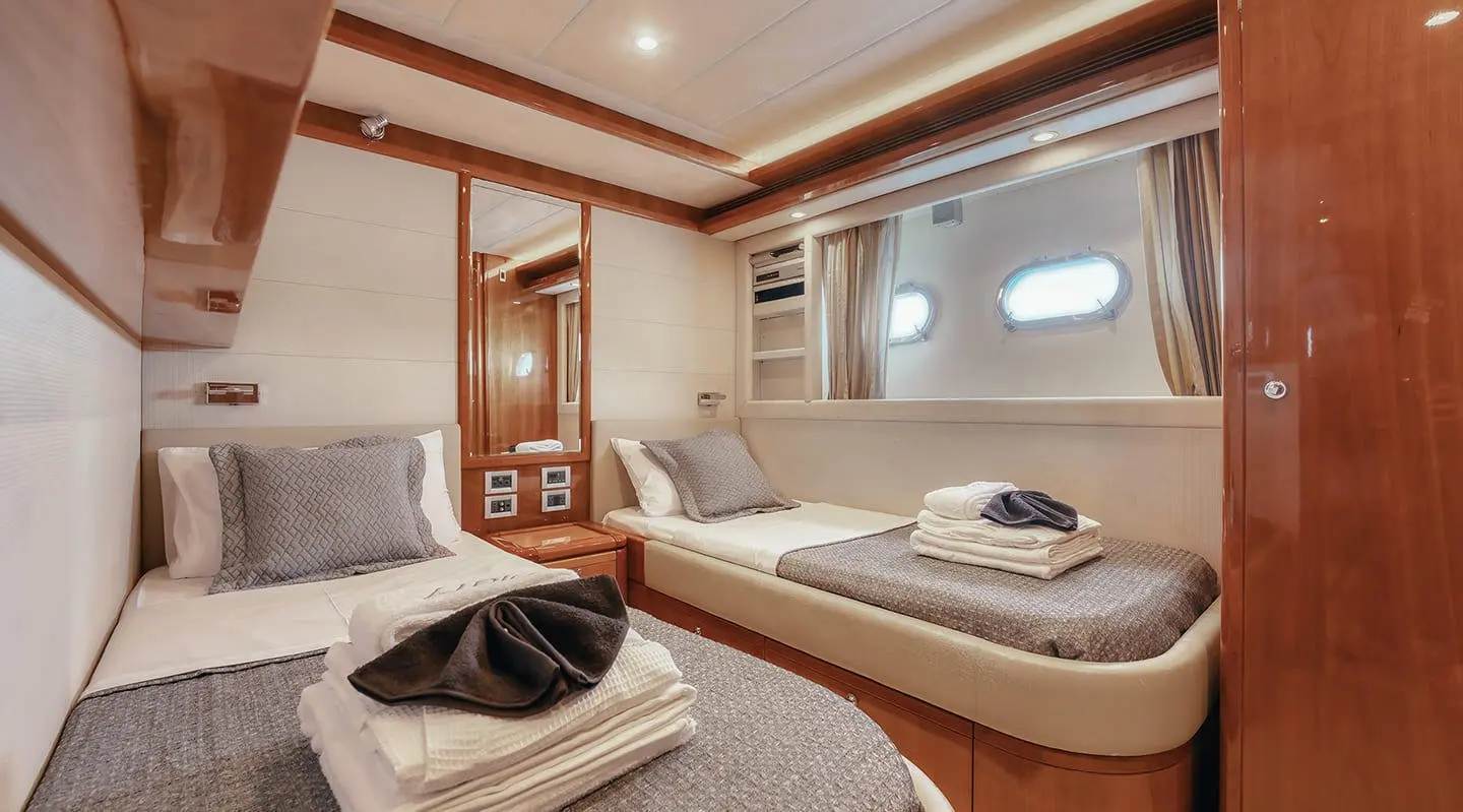 Interior of yacht Lidia: lounge with curved sofa, window, wooden cabinetry