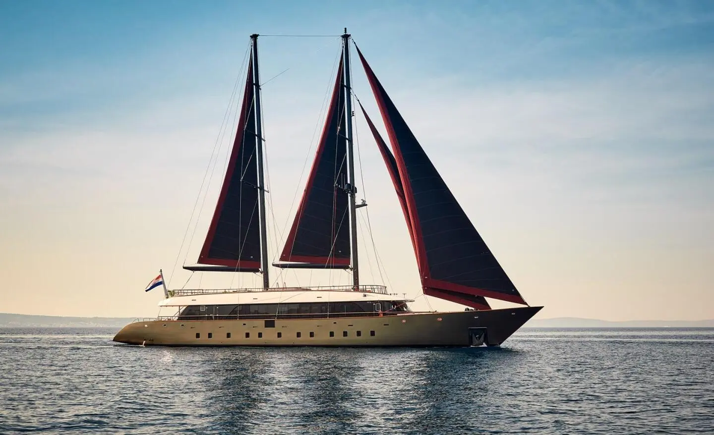 Anetta luxury sailing yacht with two dark mainsails on calm sea