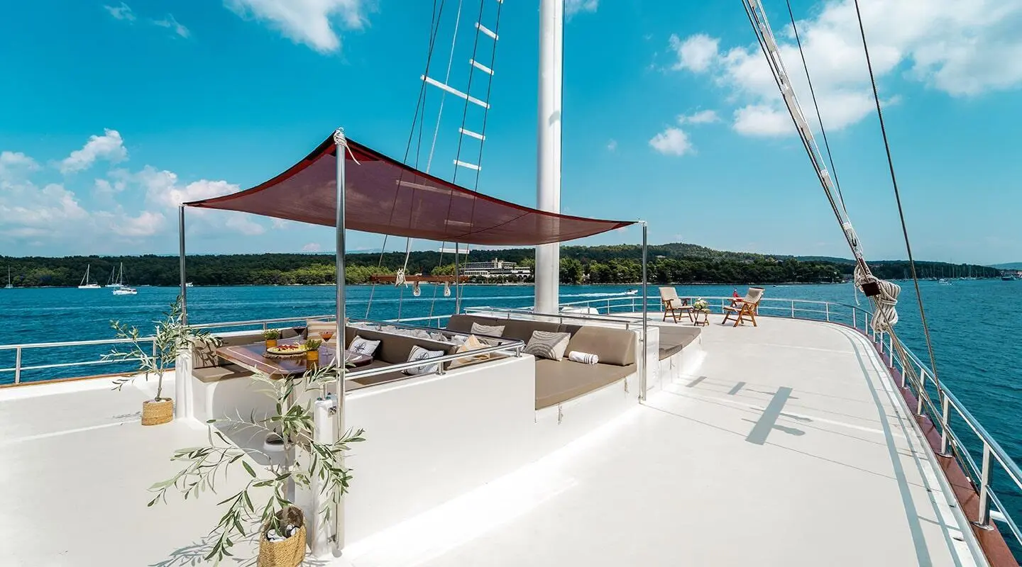 Cesarica yacht at sunset with white deck and blue sky aboard