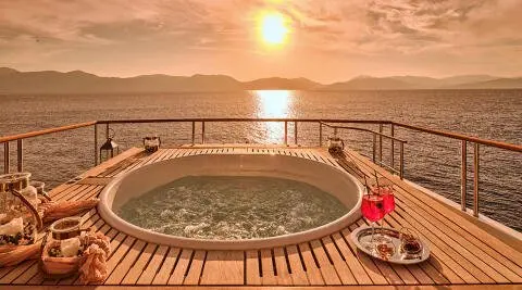 La Pellegrina 1 yacht deck at sunset with round hot tub on railing