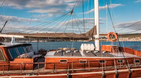 Croatia yacht on calm blue sea with sun loungers and deck, luxury wooden finish