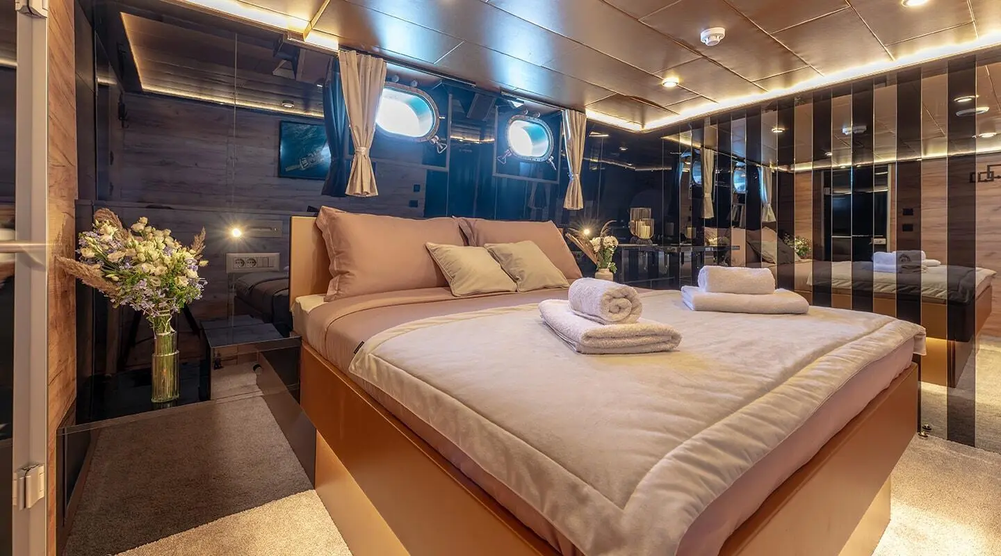 Yacht Santa Clara interior cabin with two large beds and warm lighting