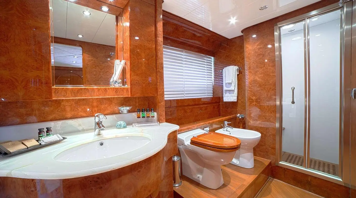 Luxurious yacht bathroom on Zoi with wooden walls, white fixtures, and a circular spa tub