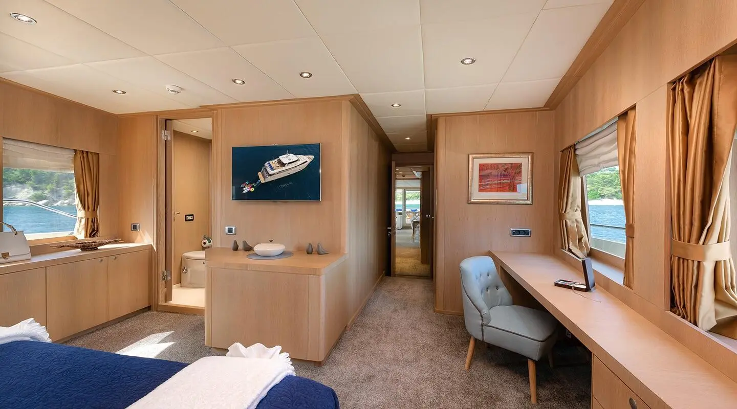 Interior of Grace motor yacht showing a cabin with bunk beds, wooden storage, and a small seating area