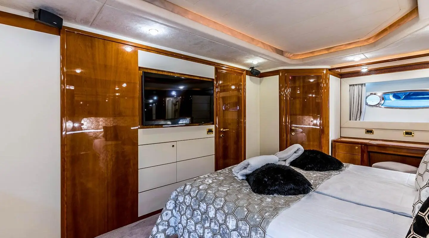 Miss Katariina luxury yacht cabin with polished wood veneer cabinets and plush bed