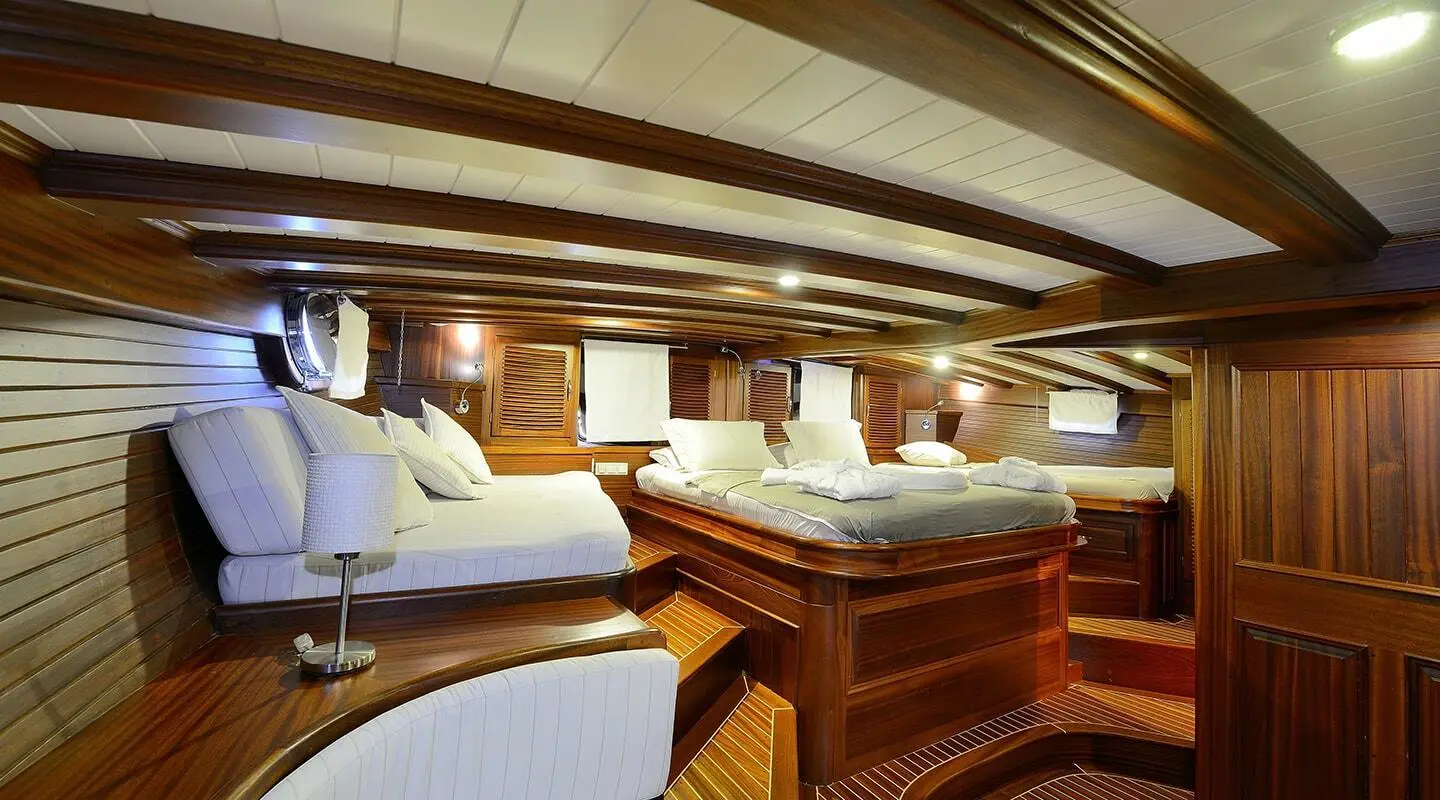 Luxurious yacht interior with wooden accents, cream seating, and dining area