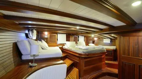 Luxurious yacht interior with wooden accents, cream seating, and dining area