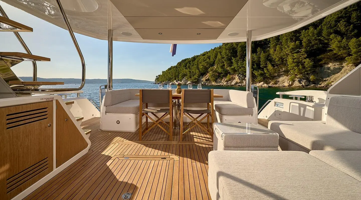 Yacht Hideaway aft deck with seating, wooden rail, and ocean view
