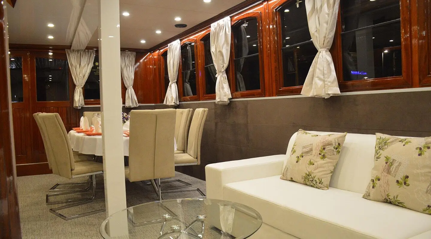 Tajna Mora luxury gulet at sunset with white furnishings on deck and beige cushions