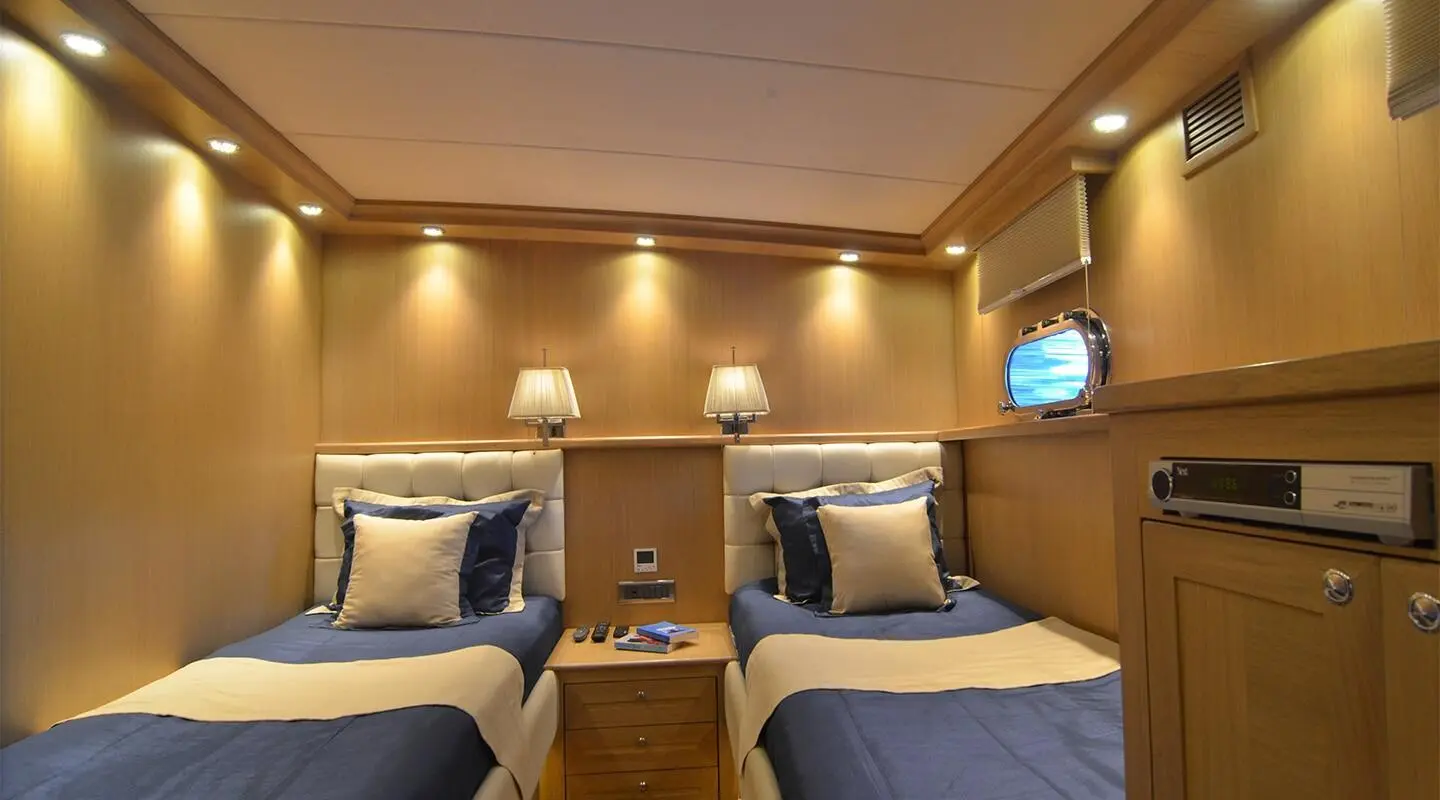 Interior of Blue Heaven yacht with twin cabins, wood paneling, and blue beds