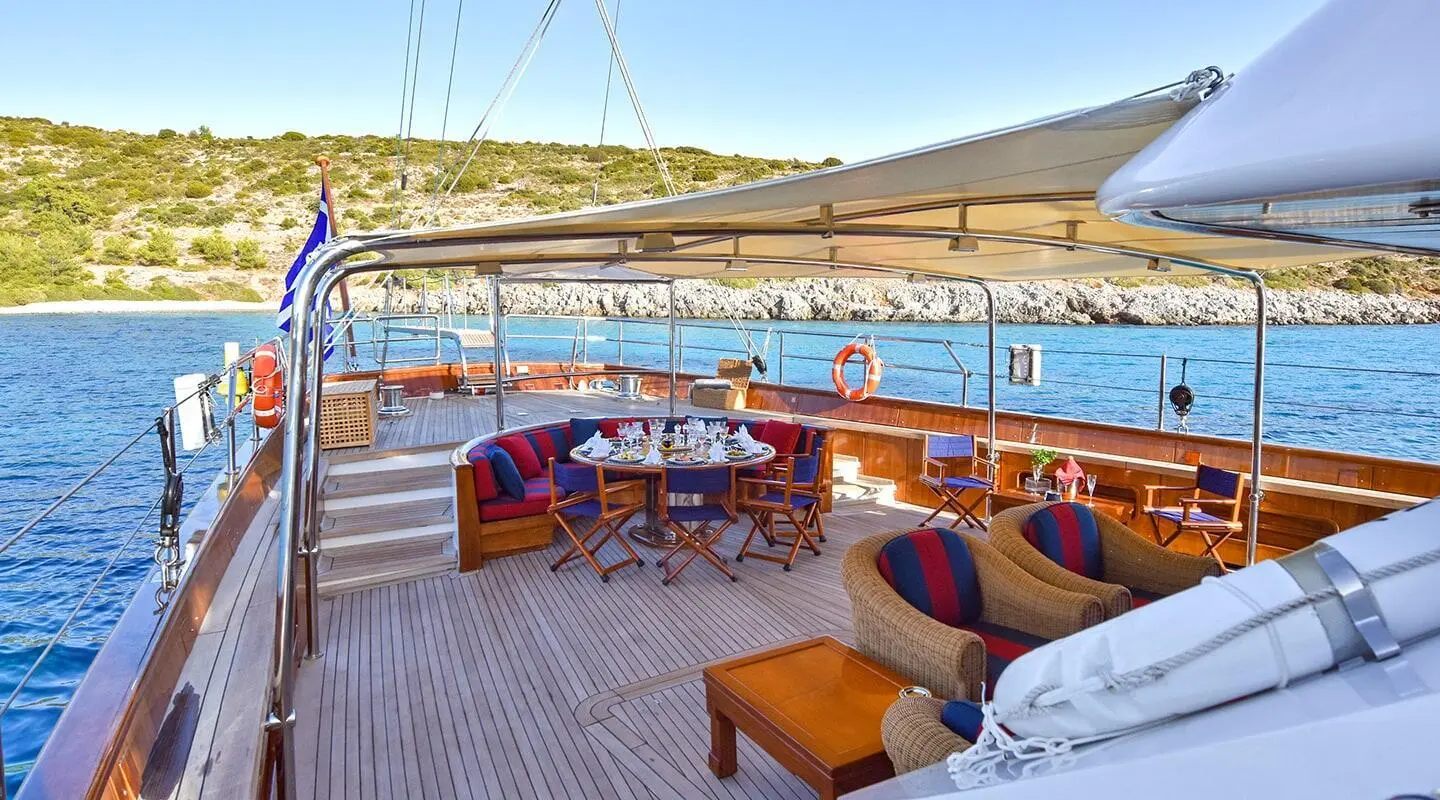 Tamarita luxury yacht deck with seating, table, and sun loungers overlooking calm sea