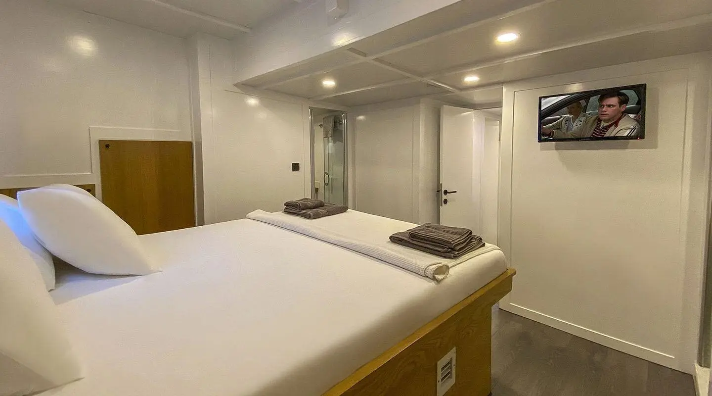 Maske 5 interior cabin with bed, portholes, and warm lighting aboard yacht