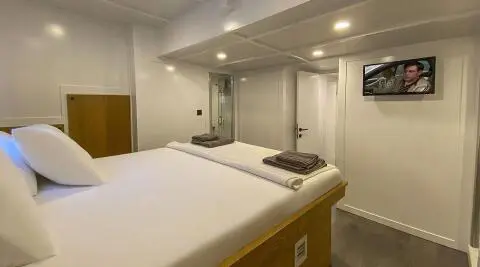 Maske 5 interior cabin with bed, portholes, and warm lighting aboard yacht