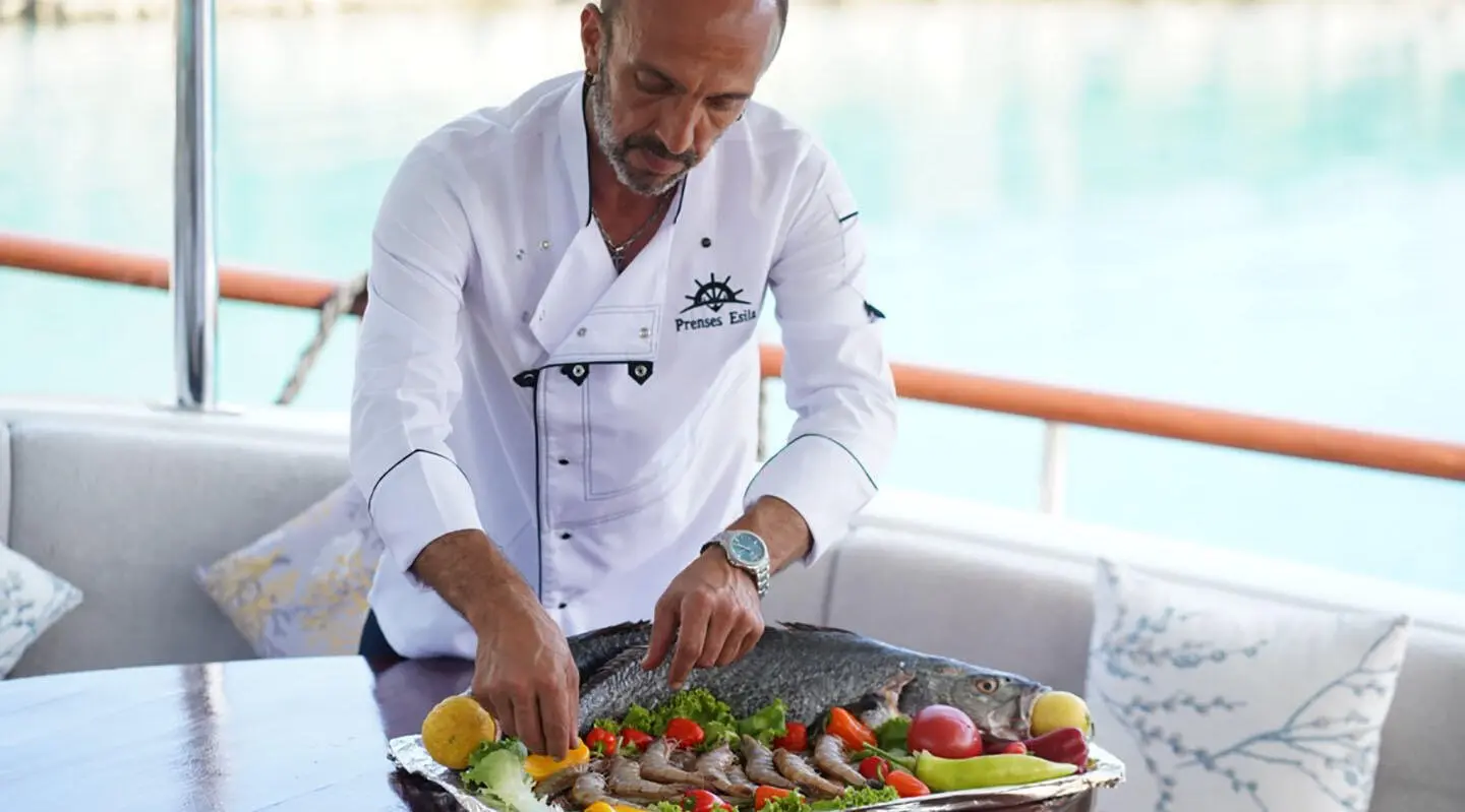 Prenses Esila yacht at sunset with guests dining on deck