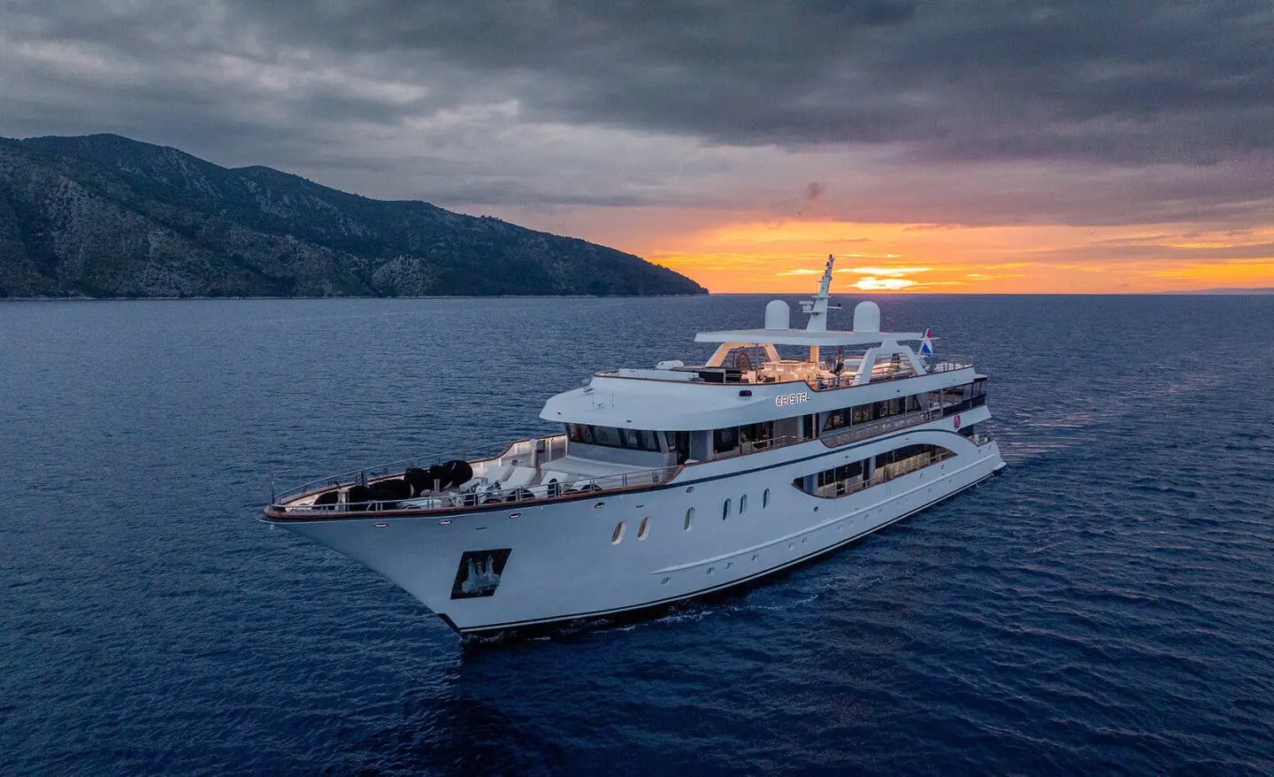 Cristal yacht at sea during sunset with white hull and upper decks visible