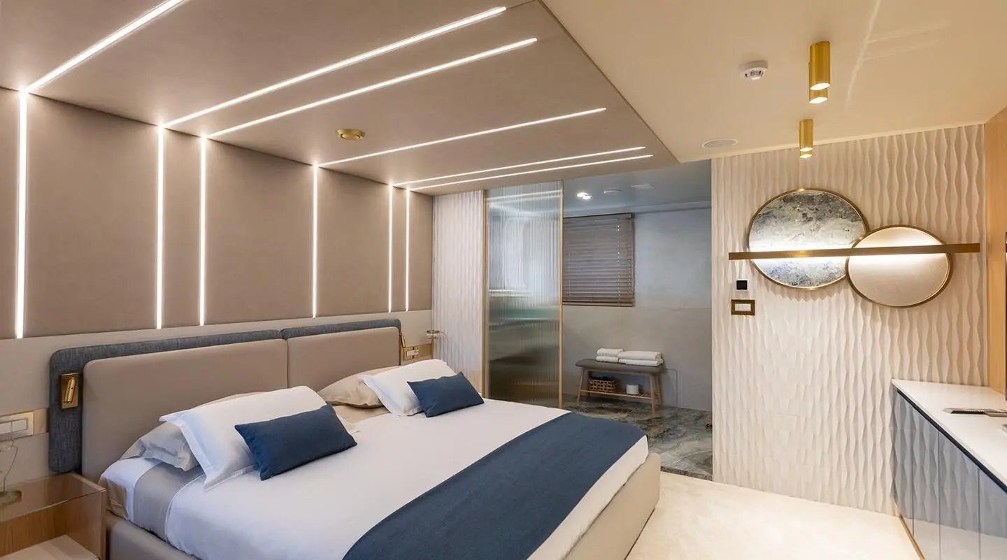 Modern bedroom interior with illuminated headboard walls and decorative mirrors