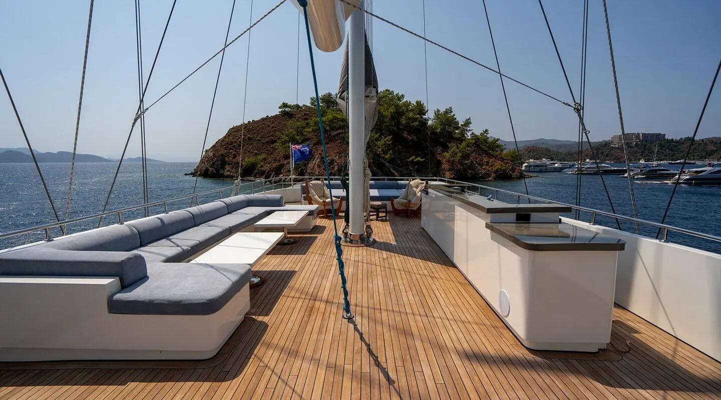 Deck view of De Love yacht with lounge seating and small island nearby