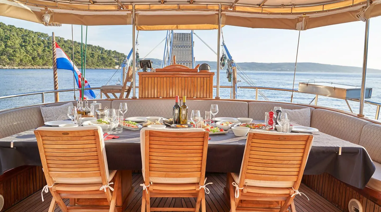 Aft deck of a gulet Libra with wooden lounge chairs facing calm sea
