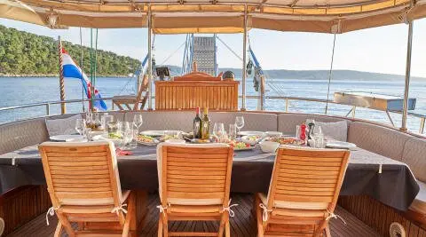 Aft deck of a gulet Libra with wooden lounge chairs facing calm sea